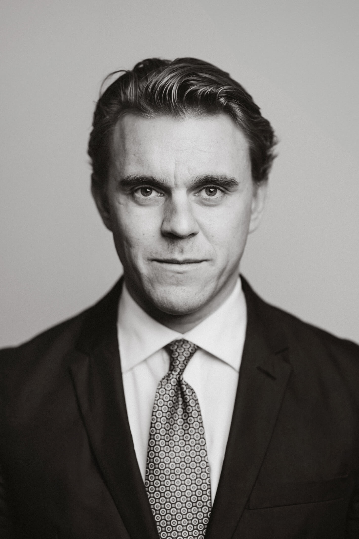 En porträtt bild av Hampus Wikerstål som tittar in i kameran, bilden är svartvit.
