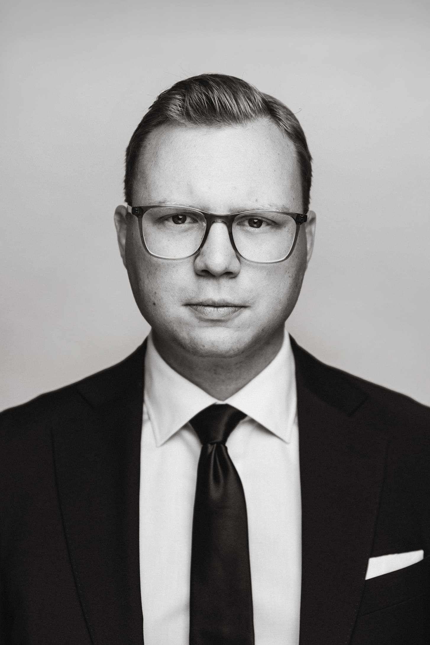 Ett svartvitt porträtt där personen tittar in i kameran.